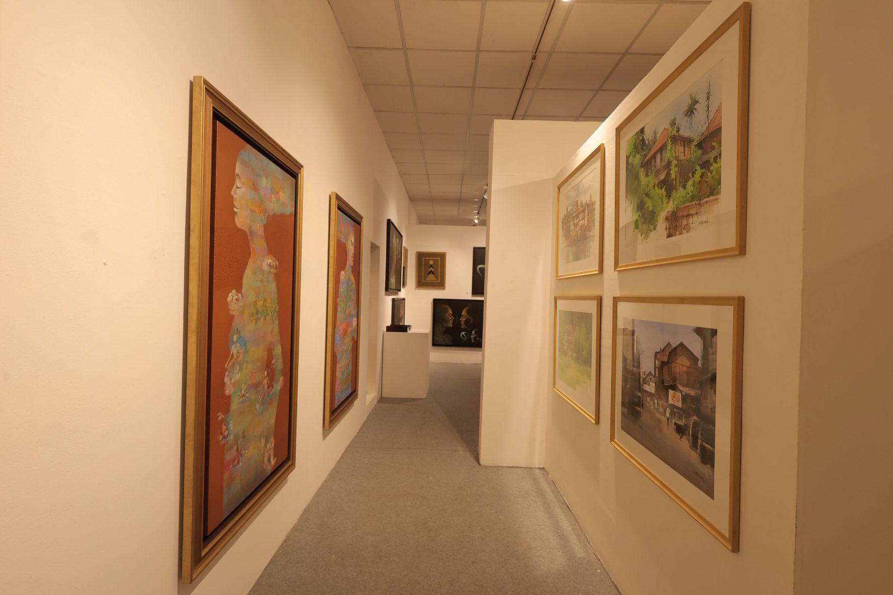 A corridor of gold-framed paintings and watercolours