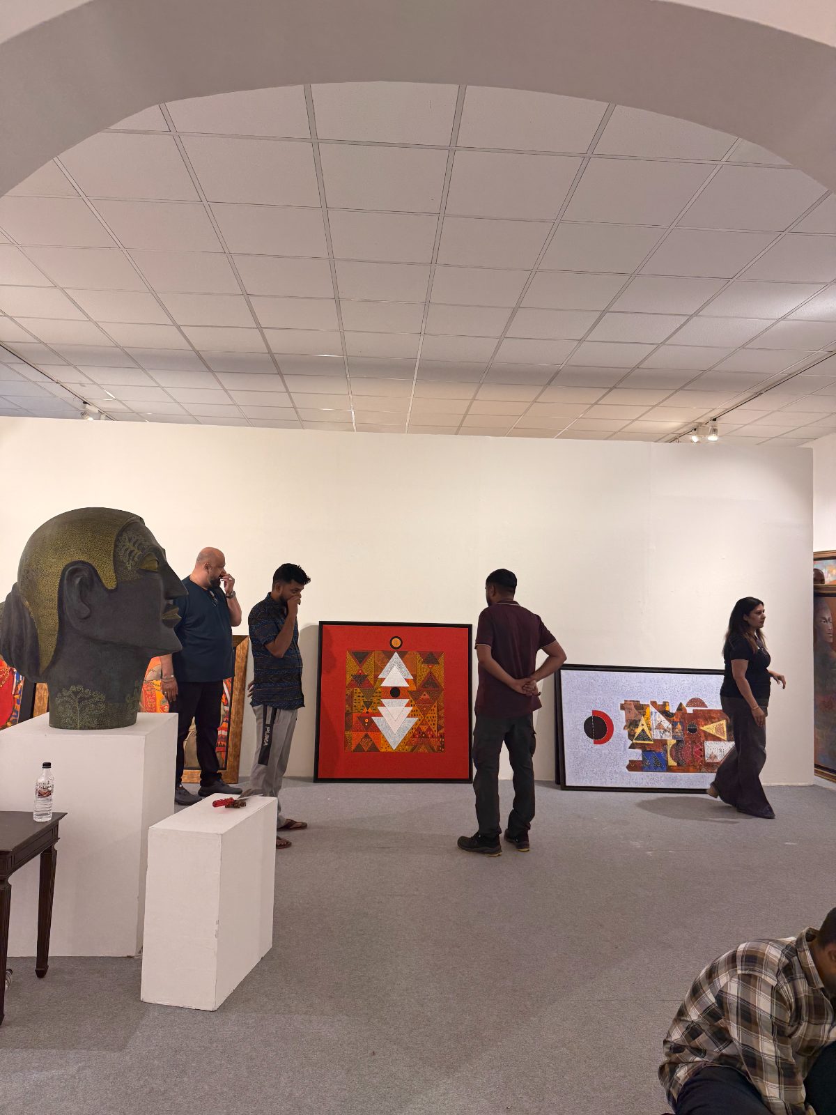 The team deciding placement beside a bronze head on a plinth