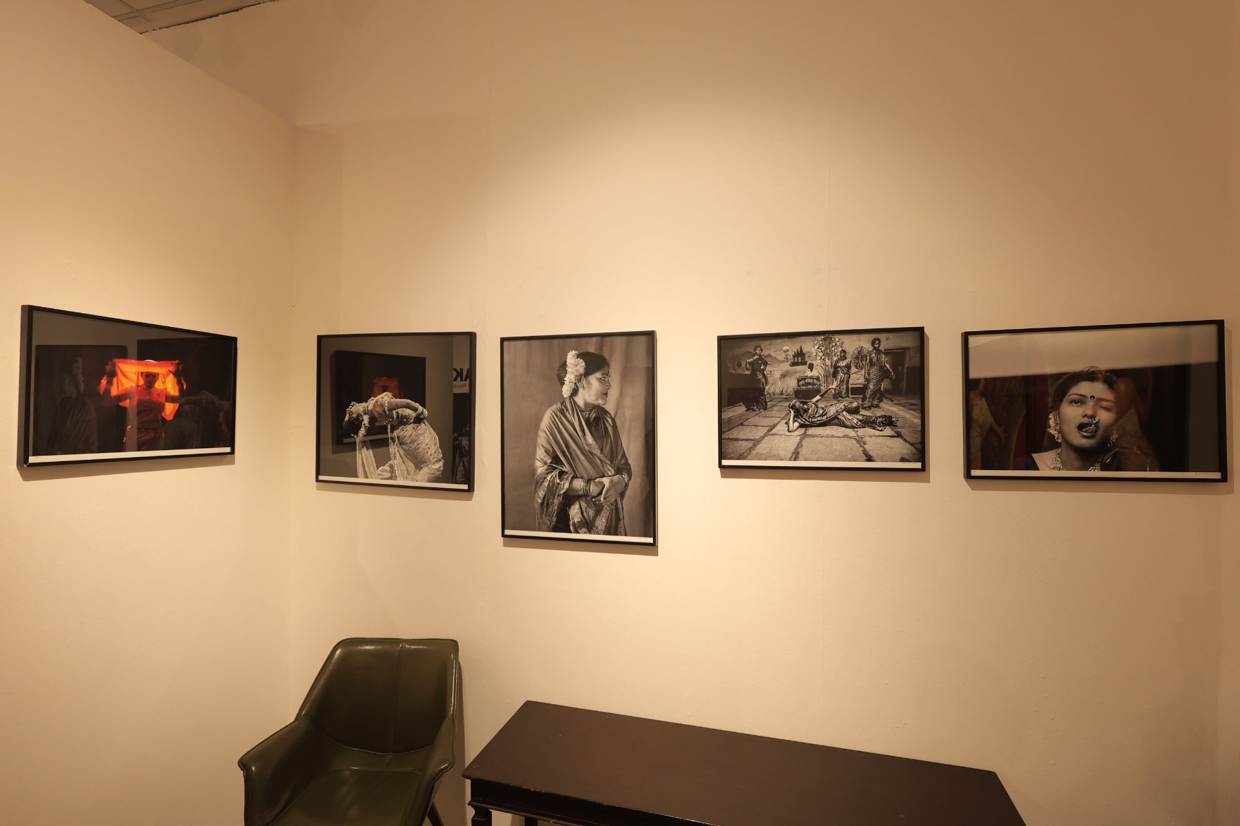A wall of Olwe’s Lavani portraits beside a leather chair
