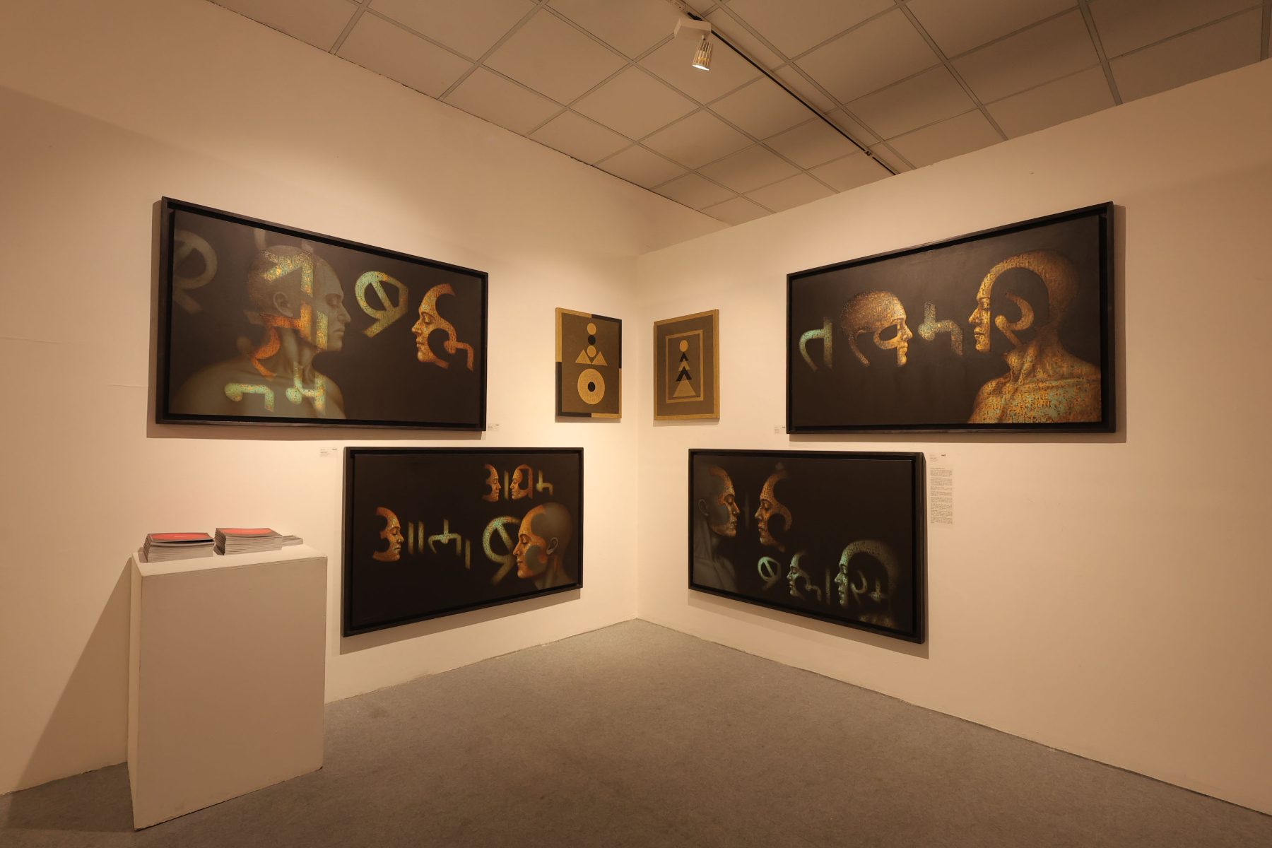 Faces formed from script, in gold on black